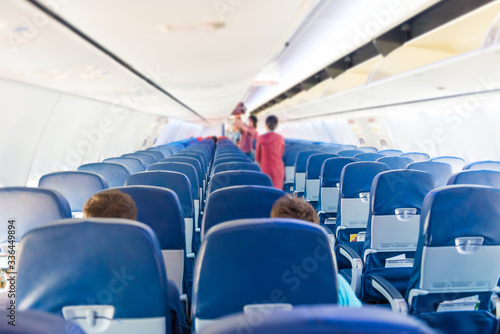 Empty plane interior with few people and stewardess during coronavirus pandemia