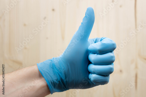 Hand with a glove making the symbol of all good, selective focus