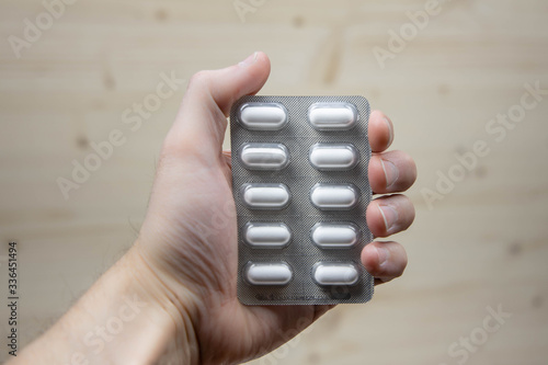 Hand holding a blister pack of medication, selective focus