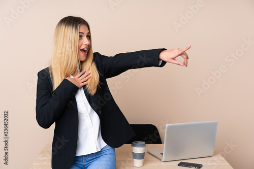 Young business woman in a office pointing finger to the side