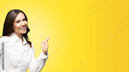Fotografie Portrait of happy smiling young excited businesswoman, showing thumb up hand sign gesture
