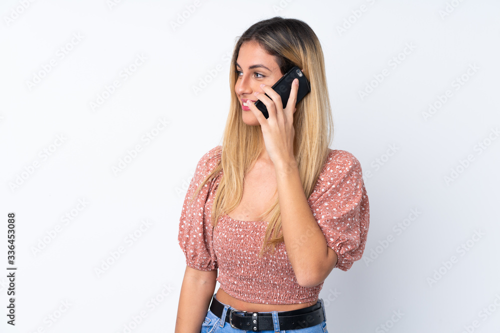 Young Uruguayan woman over isolated white background keeping a conversation with the mobile phone with someone Young Uruguayan woman over isolated white background keeping a conversation with the mobile phone with someone