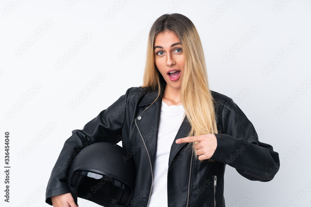 Young Uruguayan woman with a motorcycle helmet over isolated white background with surprise facial expression Young Uruguayan woman with a motorcycle helmet over isolated white background with surprise facial expression