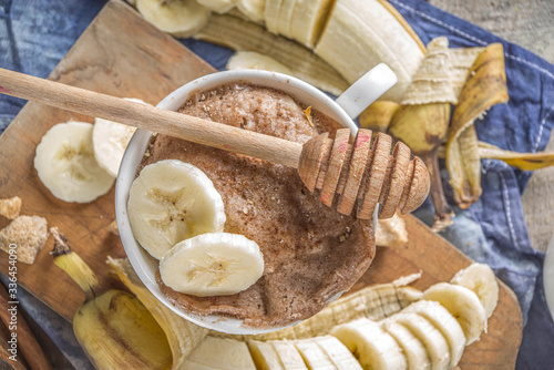 Portioned Banana bread mugcake in small mugs. Easy sweet baking idea, With fresh bananas, nuts, honey and spices on rustic wooden background copy space photo