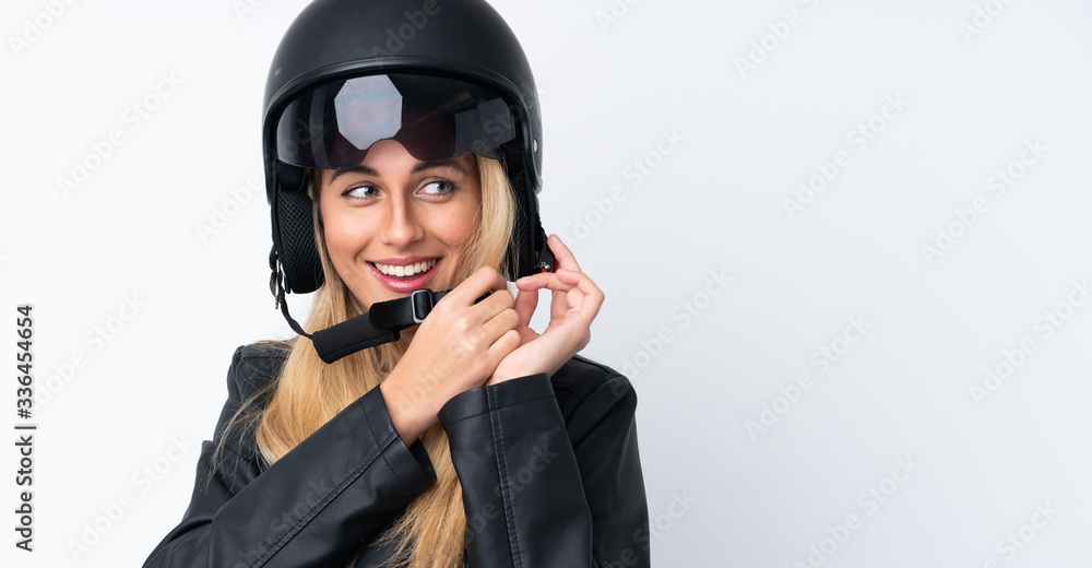 Young Uruguayan woman with a motorcycle helmet over isolated white background Young Uruguayan woman with a motorcycle helmet over isolated white background