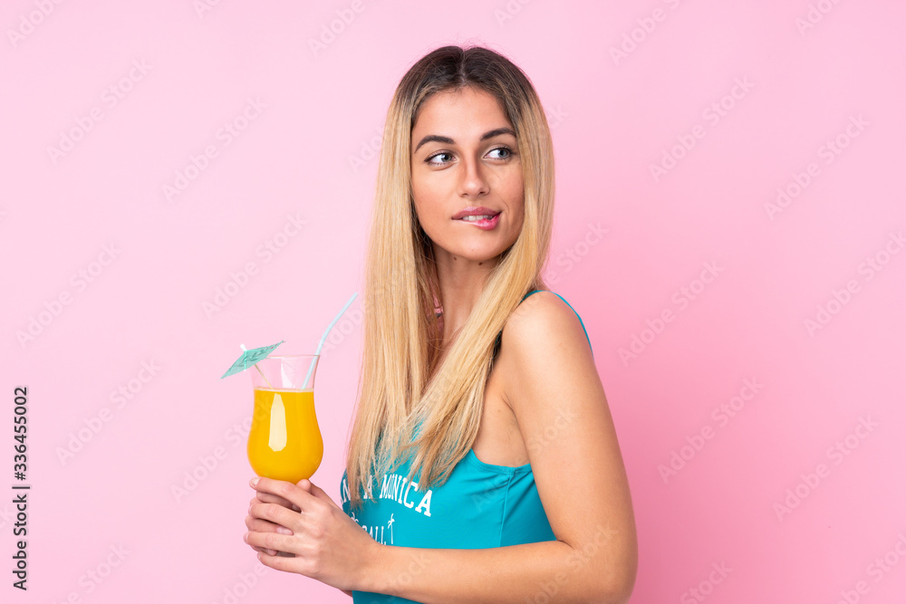 Young blonde Uruguayan woman in swimsuit in summer holidays over isolated pink background Young blonde Uruguayan woman in swimsuit in summer holidays over isolated pink background