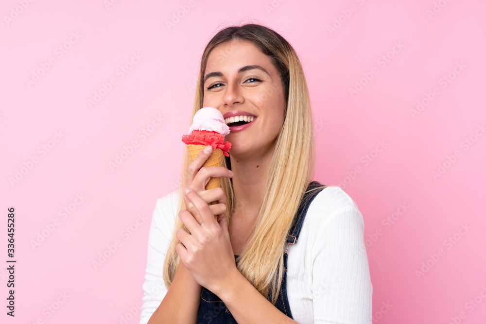 Young Uruguayan woman with a cornet ice cream over isolated pink background Young Uruguayan woman with a cornet ice cream over isolated pink background