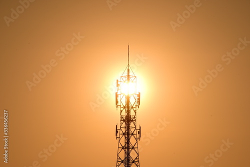 Wireless Communication Antenna With bright yellow sky in the morning sunrise .Telecommunication tower with antennas.High pole for signal transmission