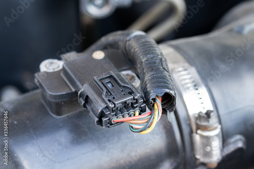 Mass air flow (MAF) sensor under the open hood of a car - measures the air flow in the engine to give the correct readings on the engine control unit (ECU) to adjust the fuel-air mixture photo