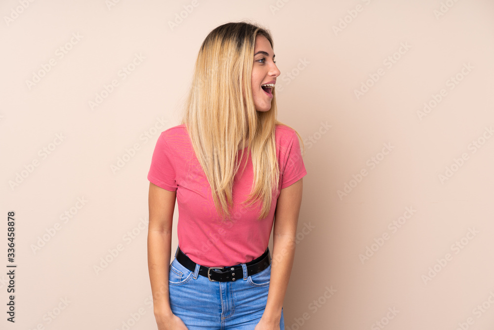 Young Uruguayan woman over isolated background laughing in lateral position Young Uruguayan woman over isolated background laughing in lateral position
