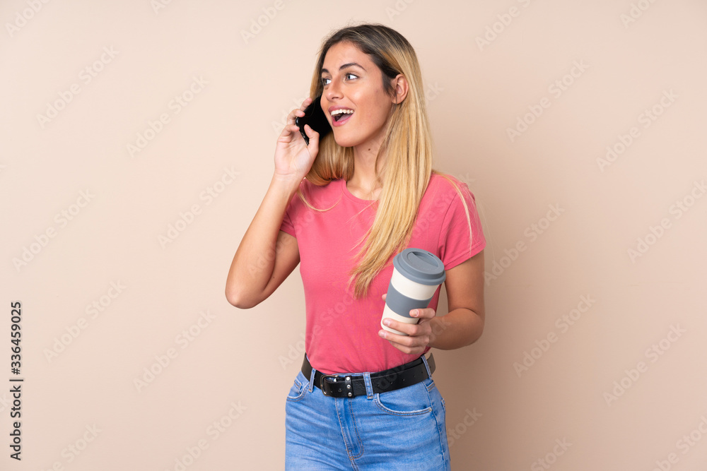 Young Uruguayan woman over isolated background keeping a conversation with the mobile phone Young Uruguayan woman over isolated background keeping a conversation with the mobile phone