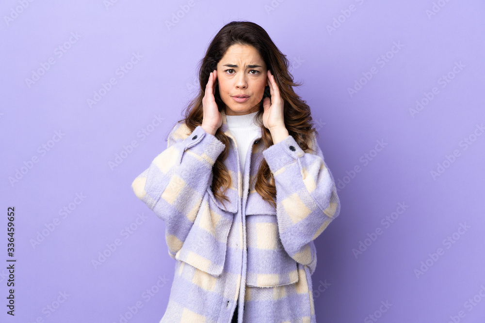 Woman over isolated purple background frustrated and covering ears Woman over isolated purple background frustrated and covering ears