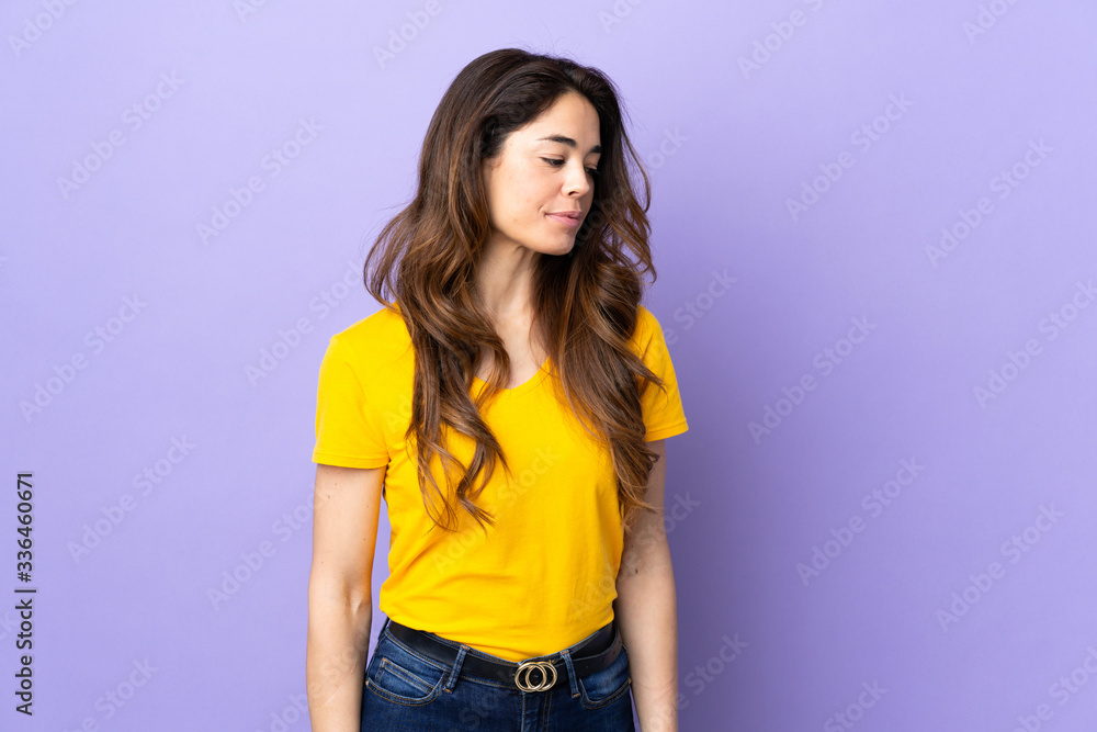 Woman over isolated purple background looking to the side Woman over isolated purple background looking to the side