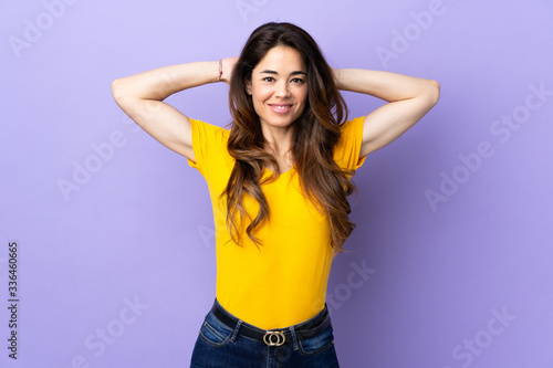 Woman over isolated purple background laughing