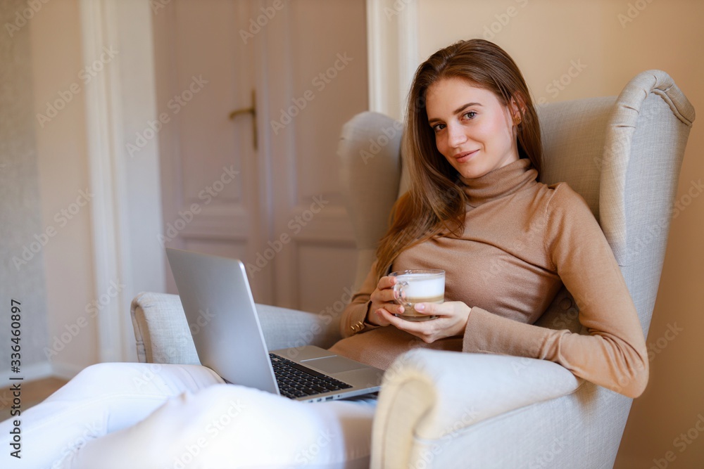 young woman using laptop and drinking a coffee young woman using laptop and drinking a coffee