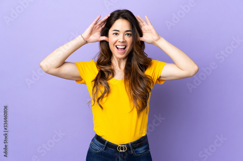 Woman over isolated purple background with surprise expression