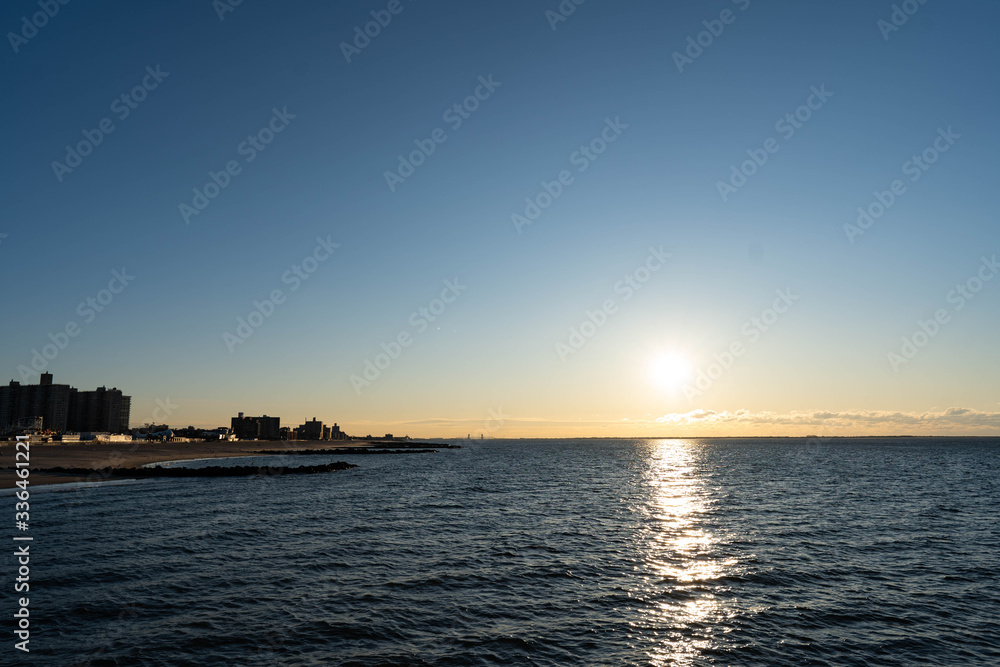 Sunrise over Atlantic Ocean, blue sky, piers. Pier and blue Atlantic Ocean. Red sky sun beams. 
