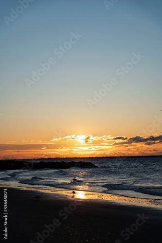 Sunrise over Atlantic Ocean with a red sky and red sunbeams and blue ocean water. 