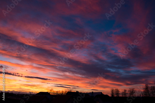 Sunset. Evening sky, clouds are painted in different bright colors: blue, red, orange, purple, pink, yellow.