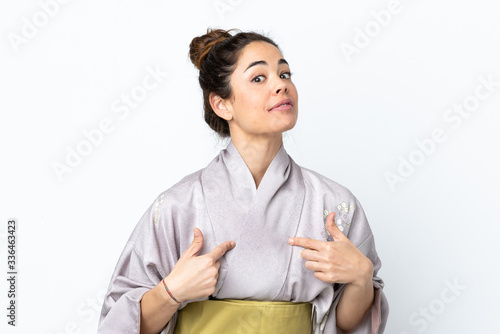 Woman wearing kimono over isolated background pointing to oneself