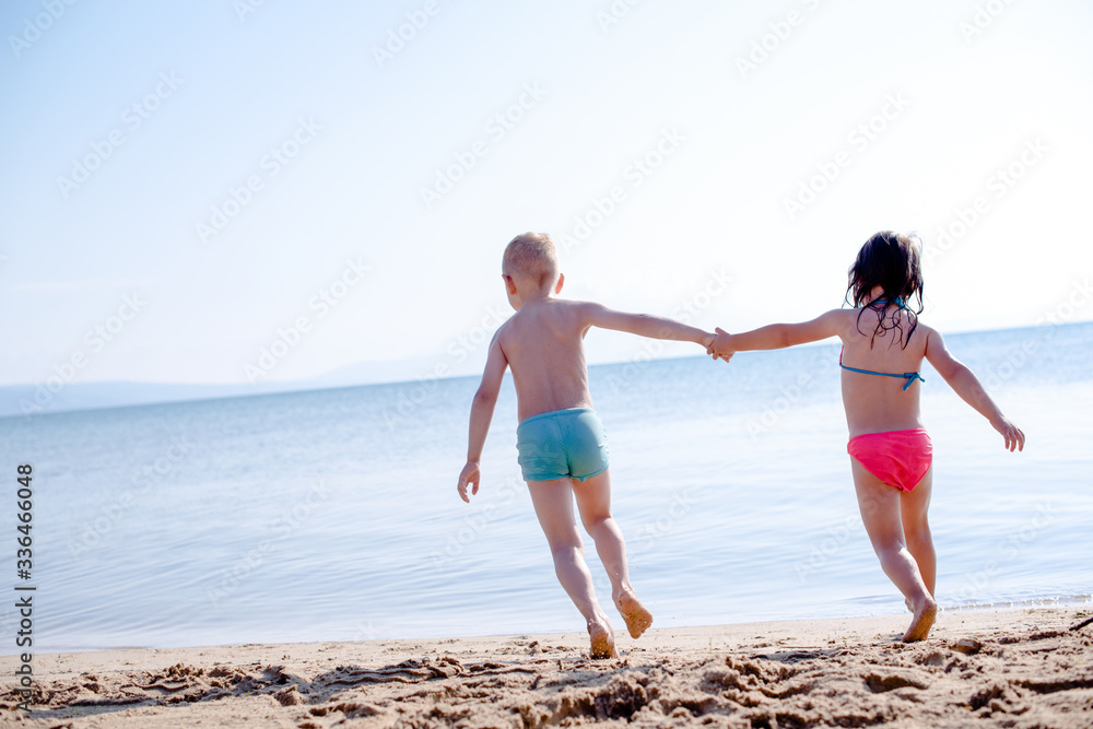 Playful holiday, kids are running on a beach