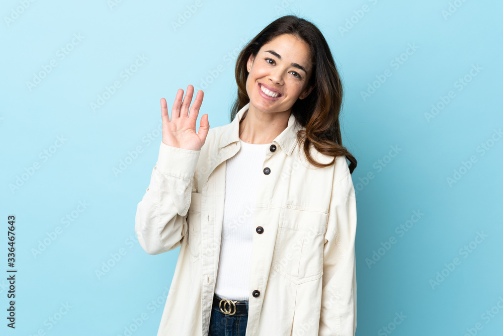 Woman over isolated background saluting with hand with happy expression Woman over isolated background saluting with hand with happy expression