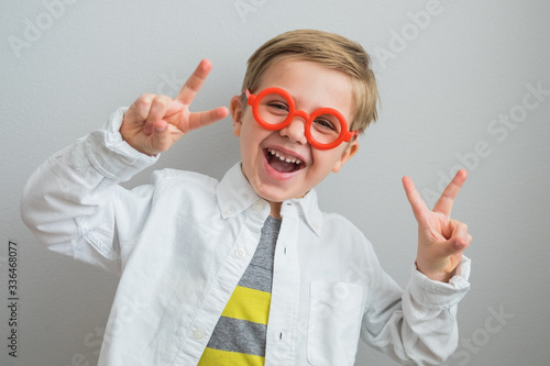 Little boy 5 years old plays a doctor in red glasses. Cheerful  emotional  cute boy laughing at the camera  portrait. Pupil with glasses  poor eyesight. Optics  glasses  education  kindergarten  