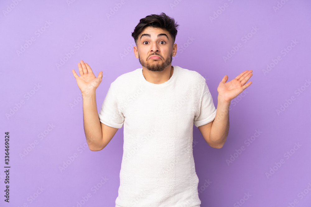 Arabian handsome man over isolated background having doubts while raising hands Arabian handsome man over isolated background having doubts while raising hands
