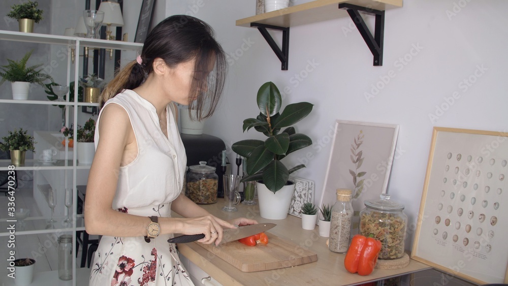 Happy smiling girl or young woman is preparing a vegetarian salad. Quarantined family life due to coronavirus. Stay at home in comfort with your family. Happy smiling girl or young woman is preparing a vegetarian salad. Quarantined family life due to coronavirus. Stay at home in comfort with your family.