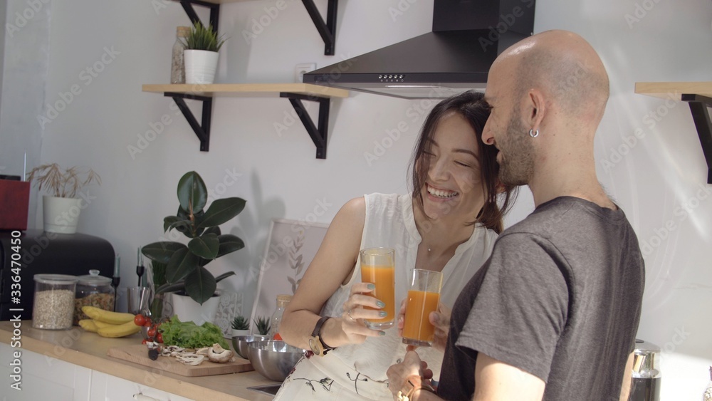 Man and a woman laugh and drink carrot juice. Friendly family stayed at home in comfort and warmth. Stay home mom. Coronavirus or COVID-19. Useful products for immunity. Girl smiles boyfriend in love. Man and a woman laugh and drink carrot juice. Friendly family stayed at home in comfort and warmth. Stay home mom. Coronavirus or COVID-19. Useful products for immunity. Girl smiles boyfriend in love.