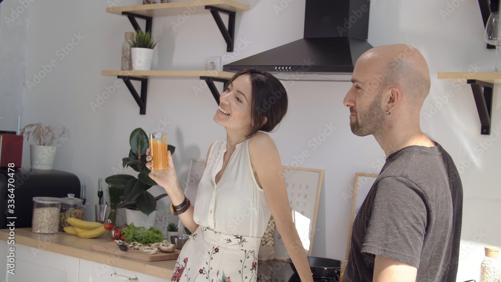 Man and a woman laugh and drink carrot juice. Friendly family stayed at home in comfort and warmth. Stay home mom. Coronavirus or COVID-19. Useful products for immunity. Girl smiles boyfriend in love. Man and a woman laugh and drink carrot juice. Friendly family stayed at home in comfort and warmth. Stay home mom. Coronavirus or COVID-19. Useful products for immunity. Girl smiles boyfriend in love.