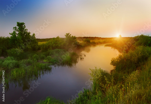 Dawn by the river in the summer spring season. Beautiful landscape of morning freshness.