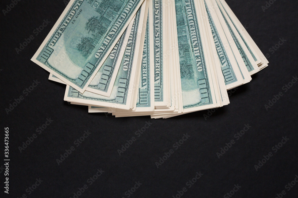 several dollar bills lying on a black background several dollar bills lying on a black background