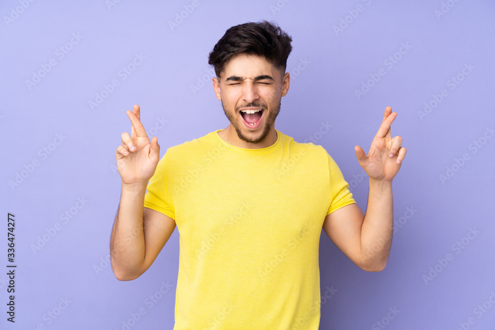 Arabian handsome man over isolated background with fingers crossing Arabian handsome man over isolated background with fingers crossing