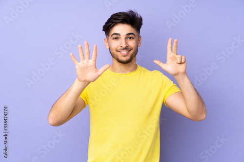 Arabian handsome man over isolated background counting eight with fingers