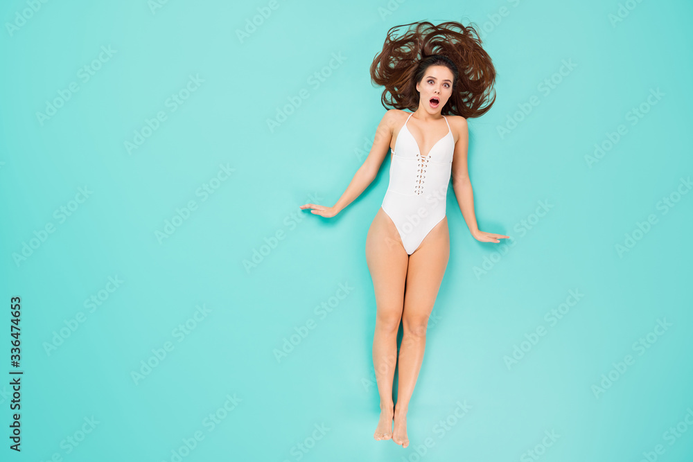 Obraz premium Top above high angle full size photo of astonished girl have summer holiday getaway awake she lay sun bathing impressed wear body suit isolated over turquoise color background