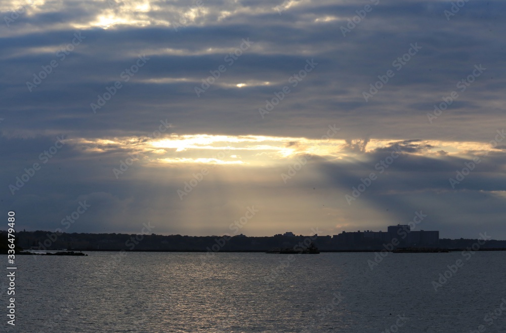 Sunbeam looking through the cloudy sky onto the water