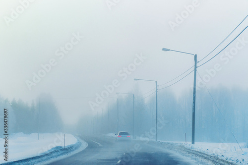 Car in the road in mist in winter Rovaniemi