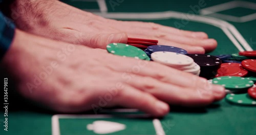 Close up of gambler pushing his chips all in the middle of the poker table shot in 4k super slow motion