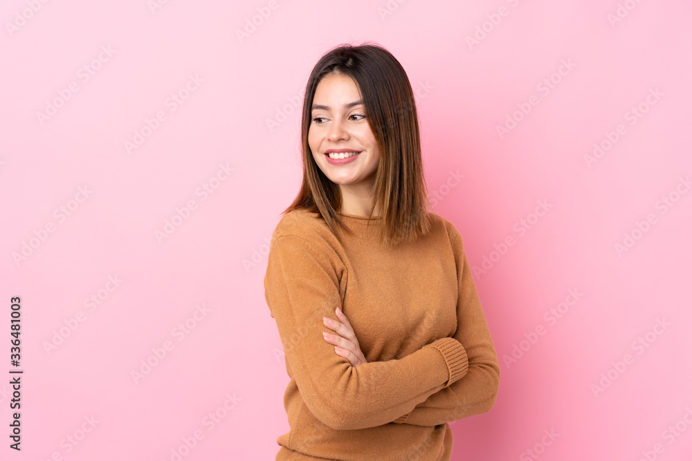 Obraz premium Young woman over isolated pink background with arms crossed and happy