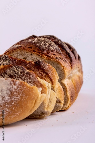 Pokrojony bochenek chleba na białym tle.