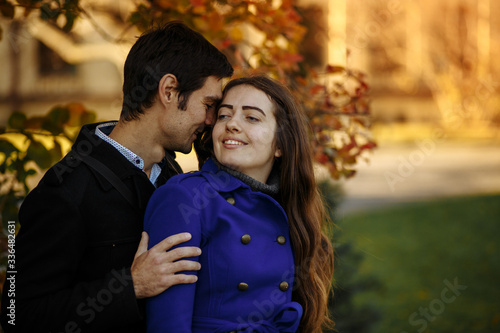 guy with a girl hug and kiss. Autumn in the park. happy day