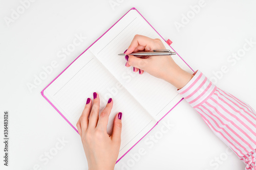 Notebook and pen in hand. Isolated on white background.