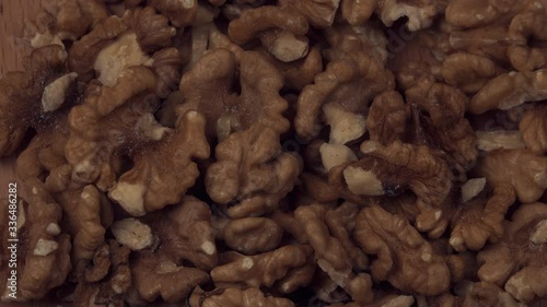 Walnut closeup. Walnut is crushed clockwise on a black background. Walnut closeup. Correctly the power on the conveyor moves.