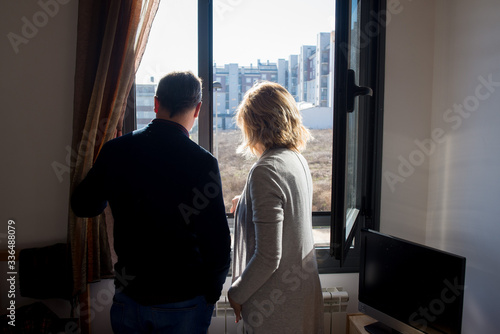 couple remains at home and looks out the window during the coronavirus crisis © rarofoto