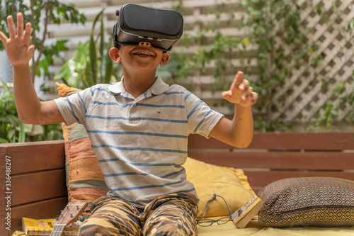 Indian Asian boy viewing through a Virtual Reality device, experiencing immersive technology