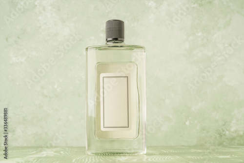 bottle of cologne with empty label over green