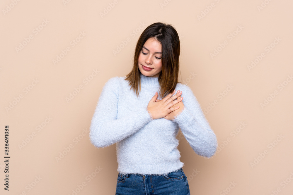 Young woman over isolated background having a pain in the heart Young woman over isolated background having a pain in the heart