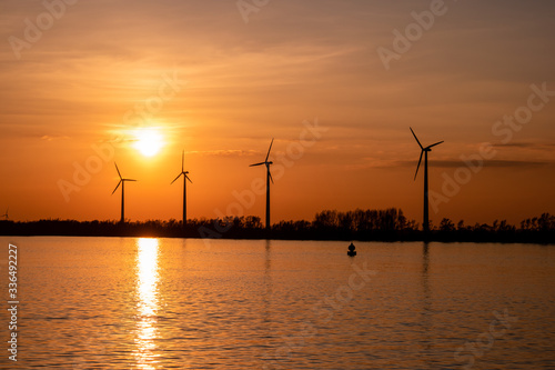 Moerdijk Netherlands, sunset winth windmills by the lake Vokerak river in Holland windmill energy sunset  photo