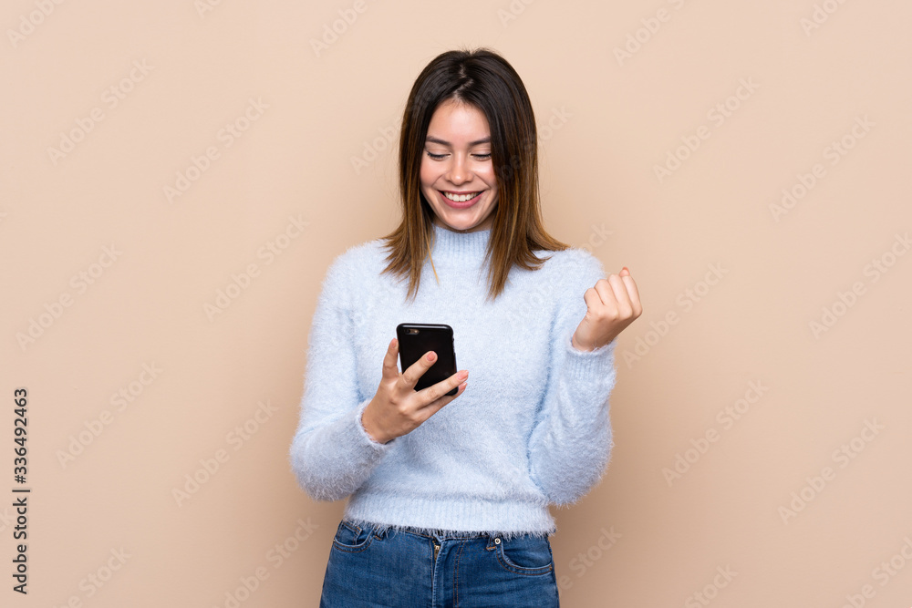 Young woman over isolated background surprised and sending a message Young woman over isolated background surprised and sending a message